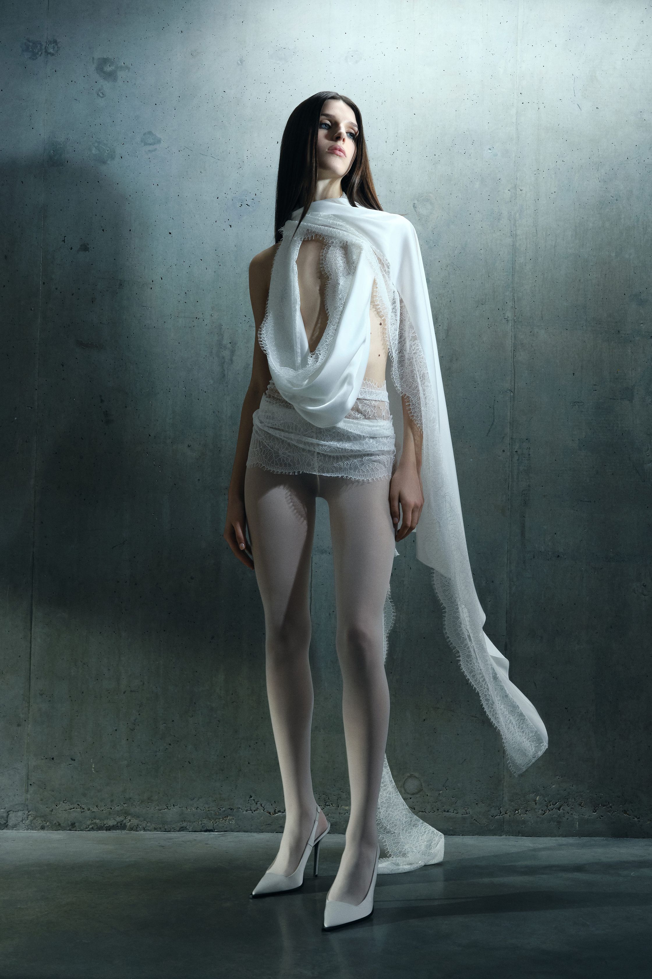 David Koma 2026秋冬以极具力量感的黑白礼服系列展现品牌标志性性感：羽毛、结构肩线与紧身剪裁共同塑造强烈女性形象。黑色连体礼服、雕塑式裙装与链条装饰构建出带有夜晚气质的时装世界。整体轮廓强调修长比例与戏剧化细节，使女性身体成为服装设计的中心-顽石频道趋势研究